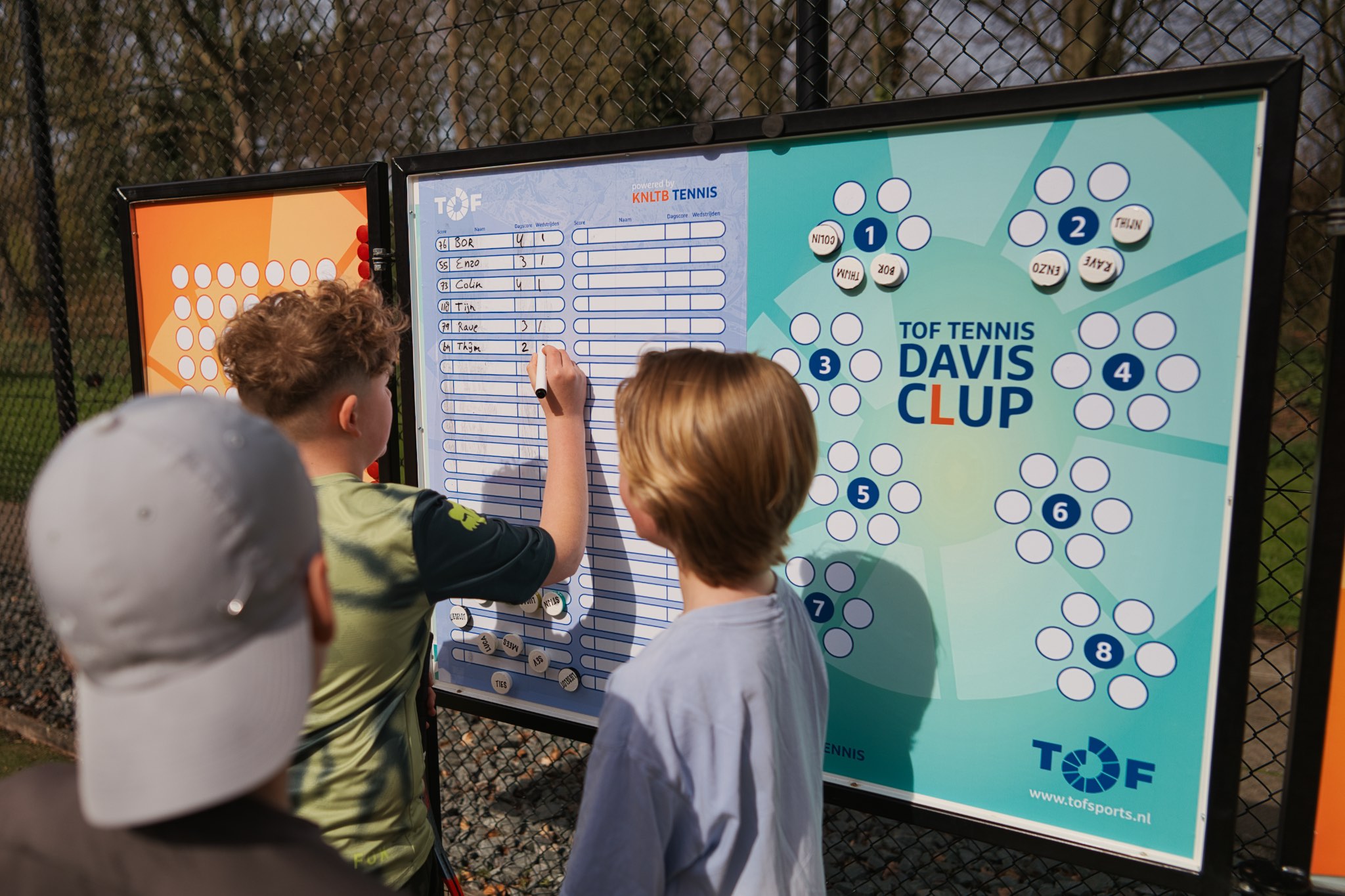 Jeugd bij het TOF scorebord op de baan