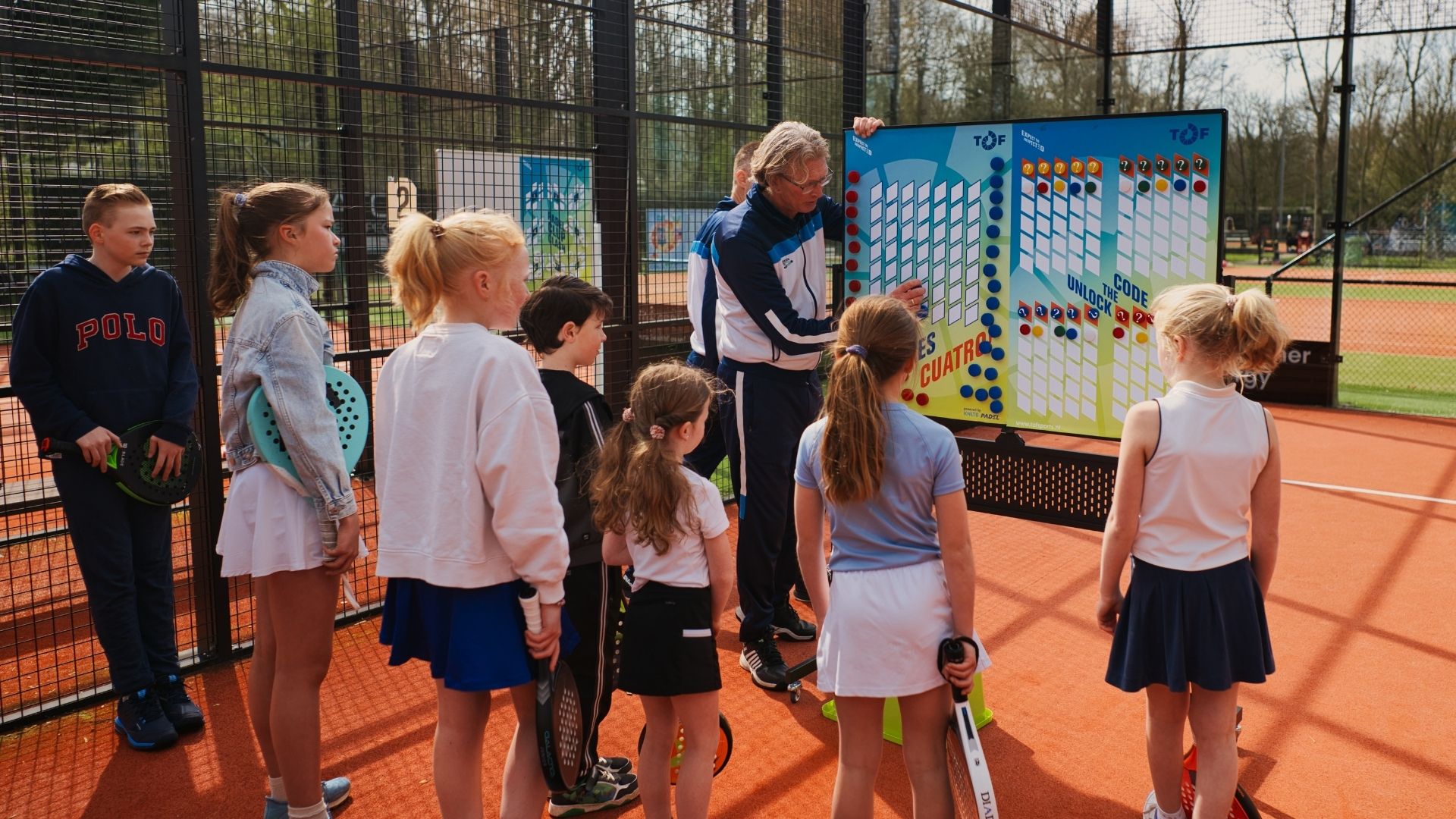 Trainer en jeugd met het TOF padelbord op de baan